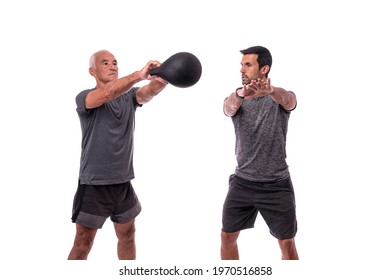 Elderly male client exercising with a fitness trainer, raises dumbbell. On a white isolated background. - Powered by Shutterstock