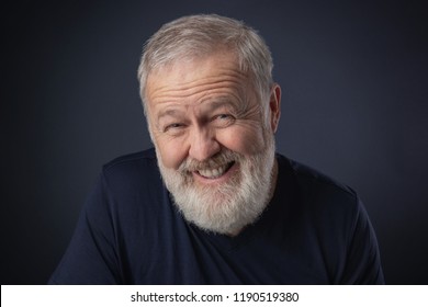 Elderly man with a beard posing with a sly, fake mime - Shutterstock ID 1190519380