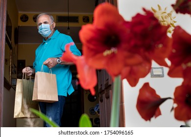 Elderly Man With Blue Polo And Face Mask, Leaves The House With Shopping Bags