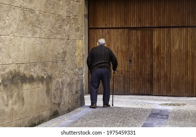 Elderly man with cane walking down the street, active retirement, lifestyle