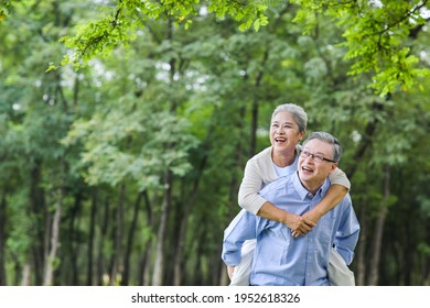 An elderly man carrying his wife in the park  - Powered by Shutterstock