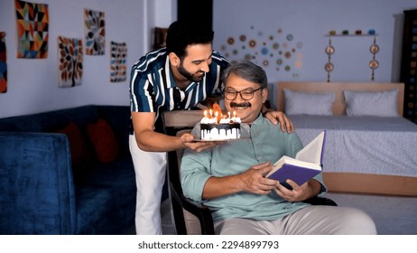 An elderly man in casual clothes with grey hair reading a book while sitting alone. Loving son bringing a birthday cake for his father decorated with candles - celebration time, relationship and bo... - Powered by Shutterstock
