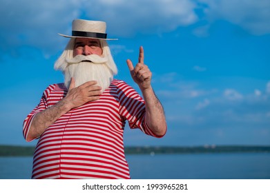 An Elderly Man In A Classic Bathing Suit Walks Along The Beach On A Hot Summer Day