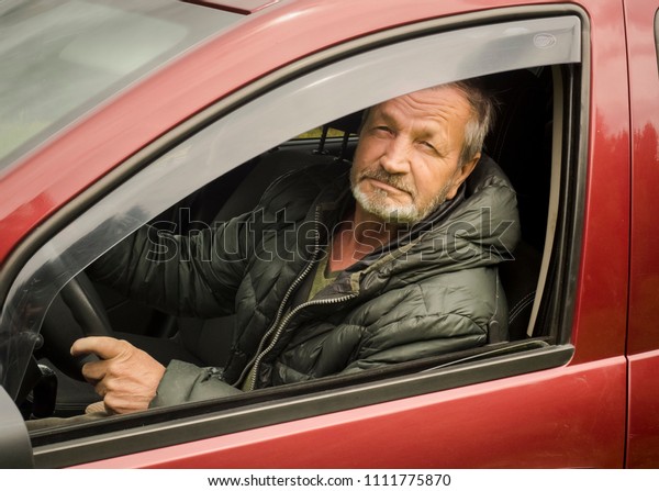 Elderly man driving a\
car