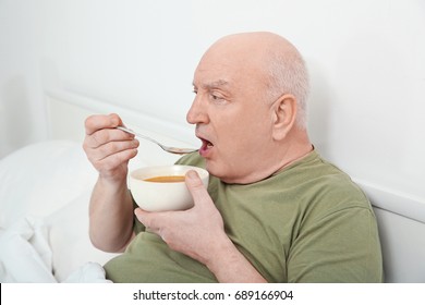 Elderly Man Eating Soup In Bed