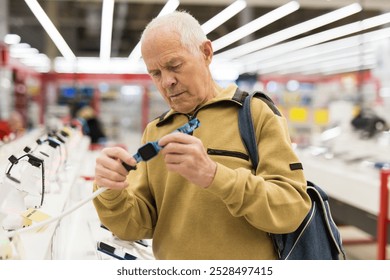 Elderly man examines smart watch in showroom - Powered by Shutterstock