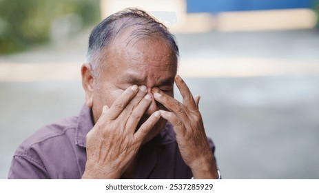 elderly man expresses deep emotion while rubbing his eyes, conveying sense of sadness or distress. His hands show signs of age, reflecting life of experiences. - Powered by Shutterstock