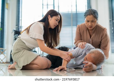 Elderly man falling down from wheelchair on lying floor after stand up. Nervous Asia daughter and his wife try to awake and support. Old elderly insurance, accident and health care concept.  - Shutterstock ID 2197693817