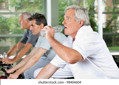 Elderly Man In Fitness Center Drinking Water From A Plastic Bottle