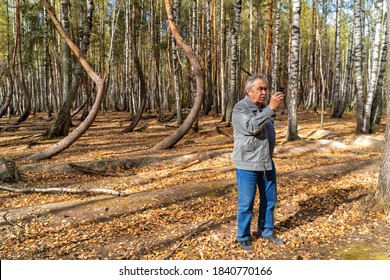 An Elderly Man Gets Lost In The Woods And Looks Around For Mobile Networks.