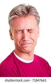 Elderly man with grey hair grimacing with disgust