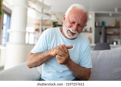 Elderly Man Has Pain In Fingers And Hands. Old Man With Finger Pain, Man Massaging His Arthritic Hand And Wrist.