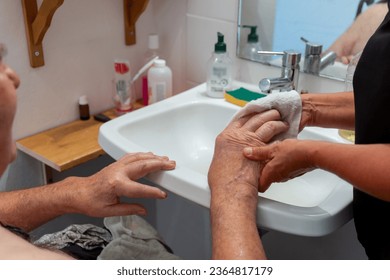 Elderly man having hand washing  hygiene care at home with nursing assistant - Powered by Shutterstock