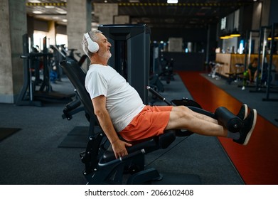 Elderly Man In Headphones Doing Abs Exercise