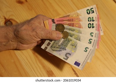 Elderly Man Holding Euro Banknotes In Hand. The Concept Of Pension, Payment And Money Savings.