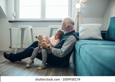 Elderly man holding his granddaughter