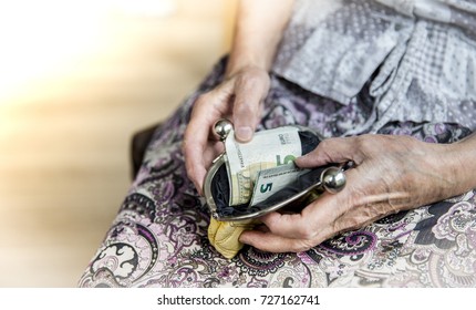 An Elderly Man Holding An Old Coin Purse And Coins .No Money. Cash