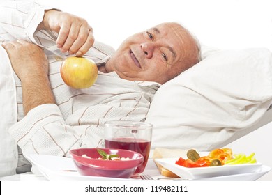 Elderly Man In A Hospital Bed Eating