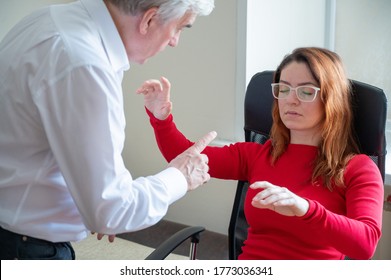 An elderly man hypnotizes a female patient. A woman in a session with a male hypnotherapist during a session. Therapist at work. Hypnosis as an alternative treatment for depression.