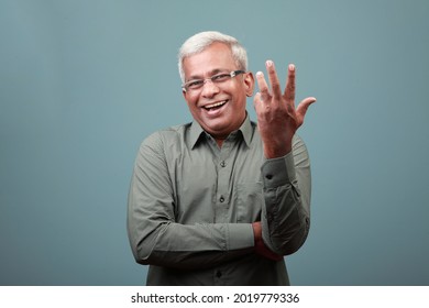 Elderly man of Indian ethnicity with a laughing expression
