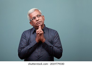 Elderly man of Indian ethnicity with a thinking face