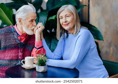 Elderly man kissing gently woman's hands sitting together, happy calm joy emotion on faces. - Powered by Shutterstock