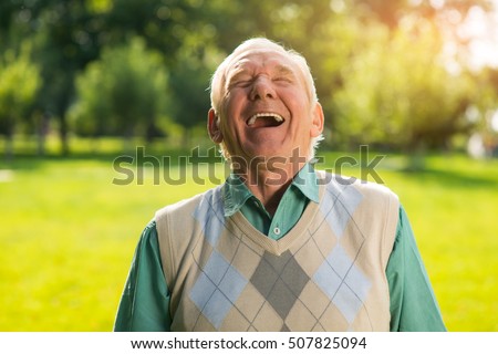Elderly man laughing. Senior male on nature background. Wonderful mood every day. Can't restrain the laughter.