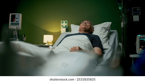 Elderly man lies in a hospital room, receiving oxygen therapy to support his breathing during recovery. - Powered by Shutterstock