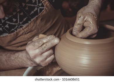 elderly man making pot using pottery wheel in studio