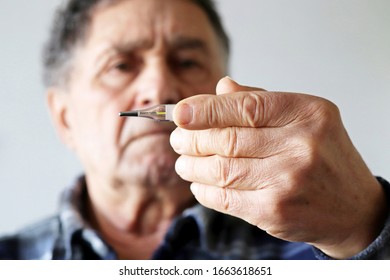 Elderly Man Measuring Body Temperature With Mercury Thermometer. Concept Of Fever, Cold Treatment, Symptoms Of Coronavirus