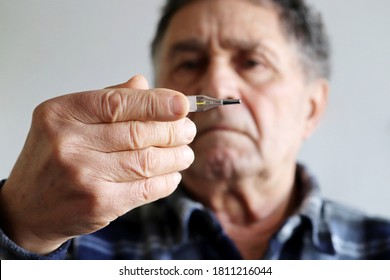 Elderly Man Measuring Body Temperature With Mercury Thermometer. Concept Of Fever, Cold Treatment, Symptoms Of Coronavirus