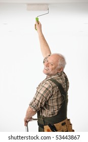 Elderly Man Painting The Ceiling In White Room.