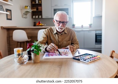 Elderly man is painting in her home  Retirement hobby 