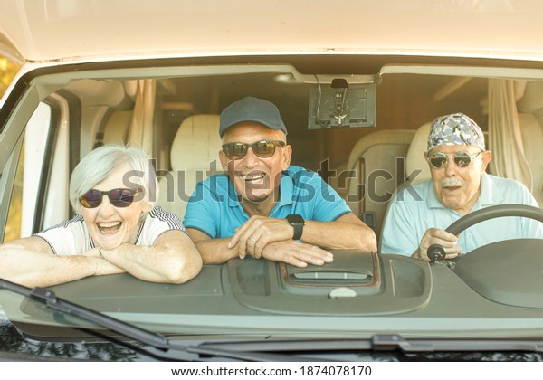 Elderly man with a patterned
bandana and sunglasses looking out of the tailgate of his
camper