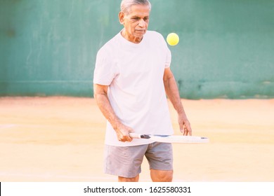 Elderly man playing tennis - Concept of healthy and fit old people - Senior player practicing tennis - Powered by Shutterstock