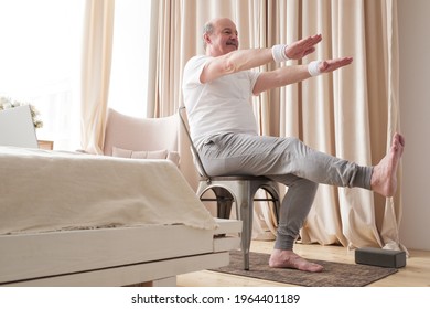 Elderly Man Practicing Yoga Asana Or Sport Exercise For Legs And Hands On Chair