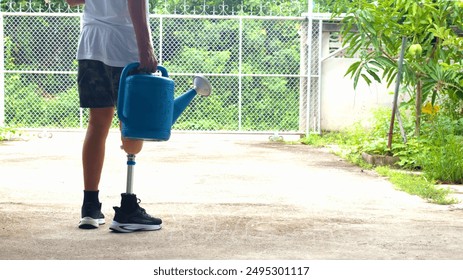 An elderly man with a prosthetic leg carries a bucket of water to water his vegetables in his garden in front of his house. The background is blurred. - Powered by Shutterstock