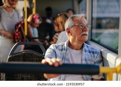 An elderly man is in a public transport bus sitting and looking through the window - Powered by Shutterstock