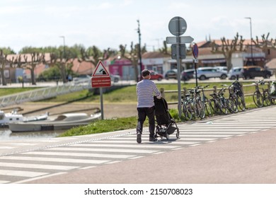 An Elderly Man Pushing A Stroller