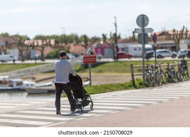 An Elderly Man Pushing A Stroller