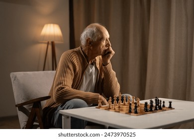 An elderly man reflects while playing a game of chess alone, highlighting contemplation and strategy. - Powered by Shutterstock