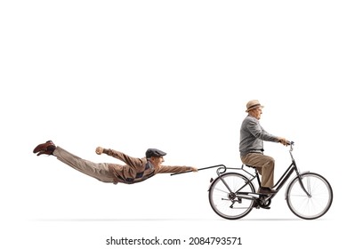 Elderly man riding a bicycle and other man flying behind isolated on white background