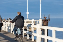 Elderly Man Riding His Bike On The Pier