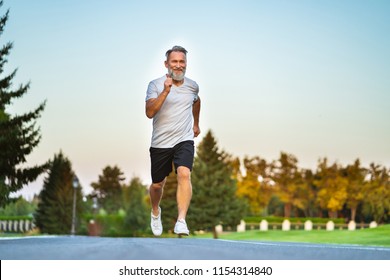 The Elderly Man Running On The Road