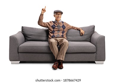 Elderly Man Seated On A Sofa Pointing Up Isolated On White Background