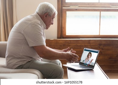 Elderly Man Sit On Couch At Home Have Online Consultation On Computer With Female Doctor Or Physician, Mature Grandfather Patient Consult Do Checkup With Nurse Talk On Video Call Use Webcam On Laptop