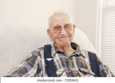 An Elderly Man Sitting In A Chair At His Home, Closeup With Copy Space