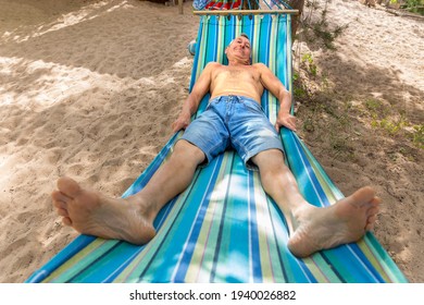 An Elderly Man Sleeping On A Hammock On A Hot Summer Day