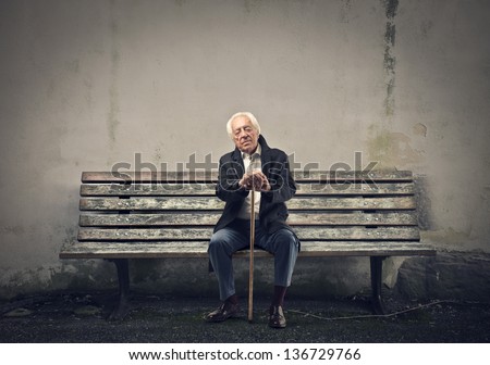 elderly man sleeps sitting on a bench