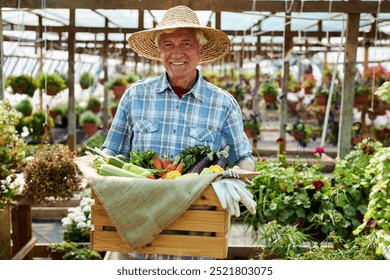 Elderly man smiling while holding freshly harvested vegetables in wooden crate, wearing straw hat and standing in lush greenhouse filled with vibrant plants and flowers - Powered by Shutterstock